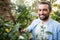 Portrait of confident gardener using hedge clippers at garden