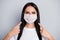 Portrait of confident girl medicine worker promoter show medical mask point index finger approve safety corona virus
