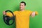 Portrait of confident guy hold steering wheel pretend drive car on green background