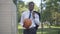 Portrait of confident happy man in suit walking with ball on outdoor basketball court and leaving. Relaxed African