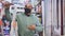 Portrait of confident Hispanic man owner of hardware store in protective face mask posing among shelving with goods. New