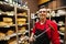 Portrait of confident male salesperson holding knife in cheese store