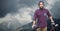 Portrait of confident male traveler holding bicycle on mountain