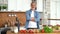 Portrait of confident man standing in kitchen, smiling, looking at camera.