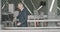 Portrait of confident mid-adult Caucasian businessman passing security check in airport. Man in formal suit putting