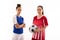 Portrait of confident multiracial young female soccer players standing against white background