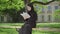 Portrait of confident Muslim woman enjoying reading outdoors on sunny day. Happy young university student sitting at