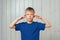 Portrait of confident preteen boy in blue t shirt pointing with fingers at head, making plan. Be smart and think