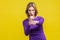 Portrait of confident purposeful businesswoman holding clenched fists ready to boxing. isolated on yellow background