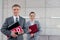 Portrait of confident realtors holding documents against wall in apartment