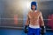 Portrait of confident shirtless boxer wearing protective sportsgear