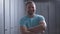 Portrait of confident sportsman crossing hands and smiling at camera. Adult bearded Caucasian man posing in gym locker