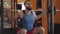 Portrait of confident sportsman squatting with barbell. Camera following young bearded Middle eastern man lifting