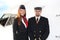 Portrait of confident stewardess and pilot standing against plane