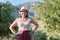 Portrait of confident woman olive farm owner, background olive trees in the mountains