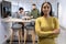 Portrait of confident young african american female advisor standing with arms crossed at workplace