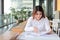 Portrait of confident young Asian business woman looking charts in her hands in office