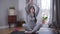 Portrait of confident young Caucasian woman meditating at home. Brunette woman raising hands up and putting down