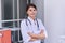 Portrait of confident young female medic with stethoscope with crossed arms