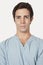 Portrait of confident young man in surgical scrubs over gray background