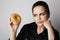 Portrait of a confused beatiful caucasian woman thinking to eat donut or not isolated over white background.