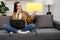 Portrait of confused young caucasian female 20s old years entrepreneur with laptop computer, sitting on grey couch and looking at