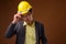 Portrait of construction businessman with hardhat against brown background