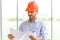 Portrait of construction engineer manager workers in orange hardhat and looking layout plan. posing standing in office.