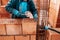 Portrait of Construction worker bricklayer using bricks and mortar for building walls.