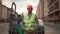 Portrait construction worker in protective overalls proudly posing against asphalt paver at construction site. Builder