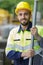 portrait construction worker stood by metal fence