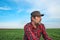 Portrait of contemplative farm worker in wheat seedling field, farmer planning agricultural activity