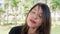 Portrait of a contemplative woman with closed eyes singing standing face closeup outdoors with trees in the background