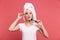 Portrait of content young woman 20s wrapped in white towel after shower applying cosmetics with makeup brush