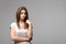 Portrait of contused thinking brunette woman. Studio shot on gray background