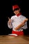 Portrait of a cook in chef clothes against black background