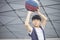 Portrait of cool Asian kid holding basketball outdoors