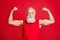 Portrait of cool powerful santa claus looking proud show biceps smile wearing sports wear isolated over red background