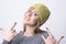 Portrait of cool young funky girl with yellow cap showing heavy metal horn sign