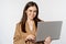 Portrait of corporate woman working with laptop, smiling and looking assertive, white background