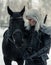 Portrait of cosplayer in image of a character Geralt of Rivia from the game or film The Witcher next to a horse in forest