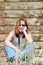 Portrait country woman with red hair leaning against timber shed