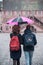 Portrait of couple with pink umbrella on cobbles place in the ci
