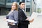 Portrait of couple professionals who are posing with laptop and folder