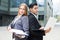 Portrait of couple professionals who are posing with laptop and folder