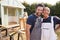 Portrait Of Couple Taking A Break From Building Outdoor Summerhouse In Garden