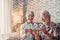 Portrait of couple of two old pensioners holding together numbers of 2023 at home. Close up of new year numbers, celebrating and