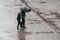 portrait of couple walking with umbrella on cobbles place