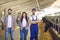 Portrait of a couple of young farmers people together with a farm worker in a cowshed.