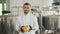 Portrait of a craft cheese worker. A cheesemaker inspects the cheese and looks at the camera. Craft cheese production